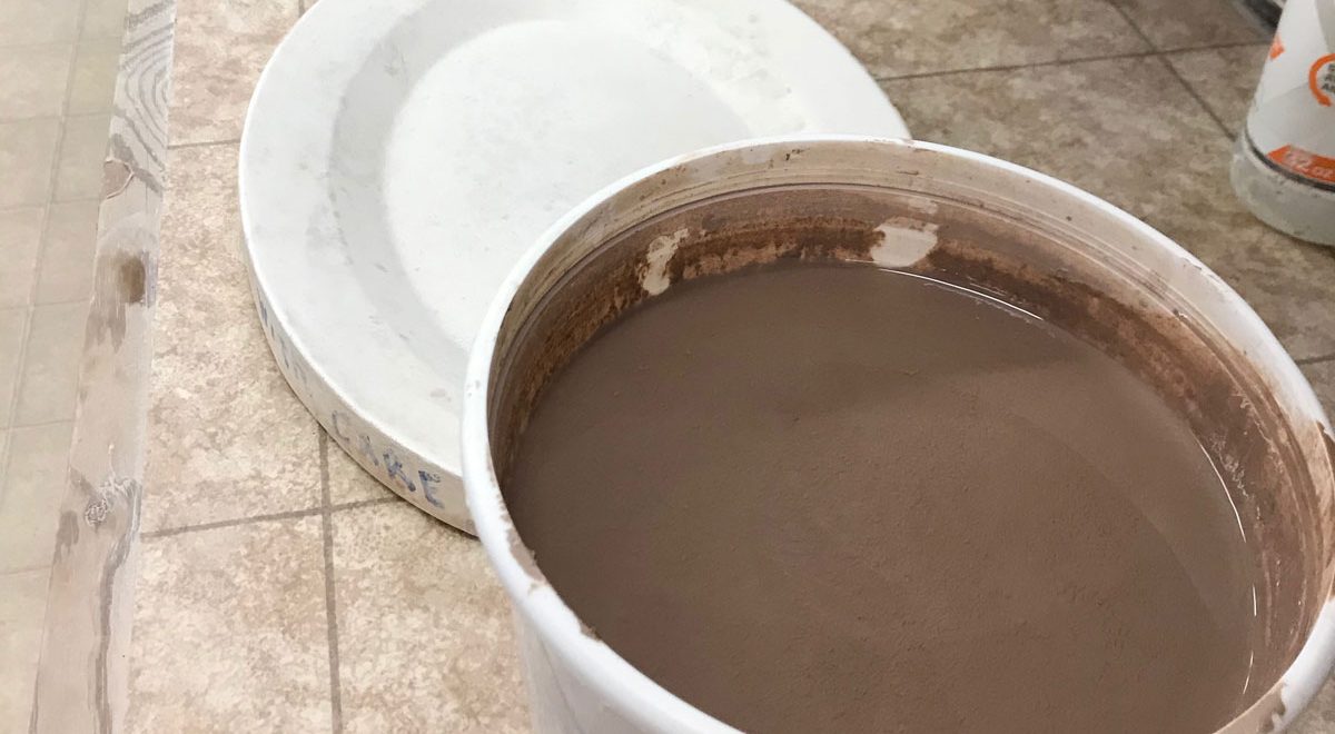 bucket of reclaim clay sludge next to plaster form