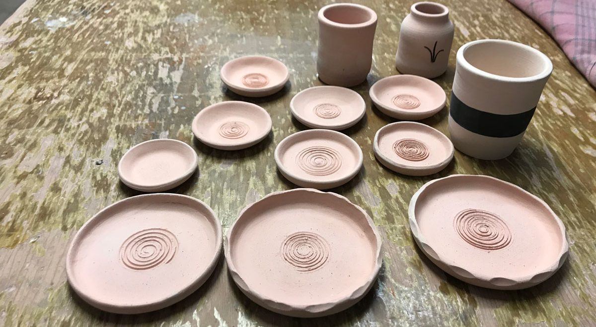 a collection of bisque fired garlic graters, bud vase & pots